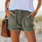 Lightweight and loose-fitting denim shorts with large pockets and fringed details.